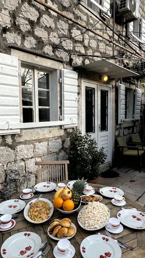 Free Charming outdoor dining scene with a rustic table full of fresh fruits and pastries. Stock Photo