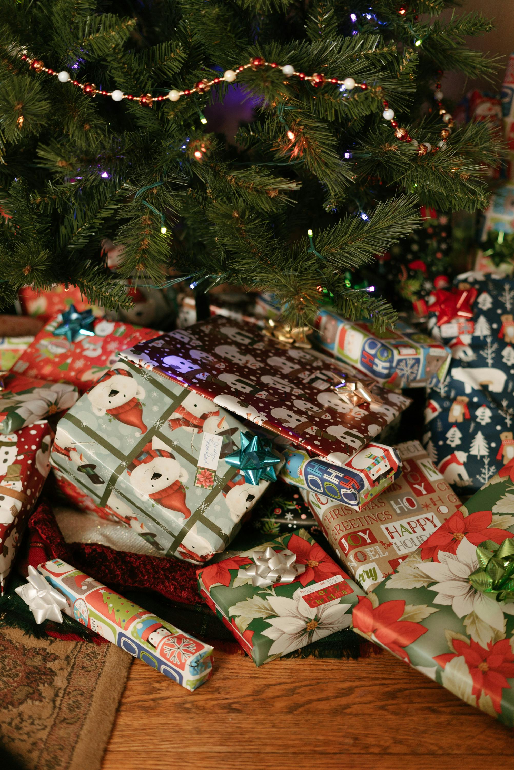 A decorated Christmas tree surrounded by an array of colorful wrapped gifts, creating a festive atmosphere.
