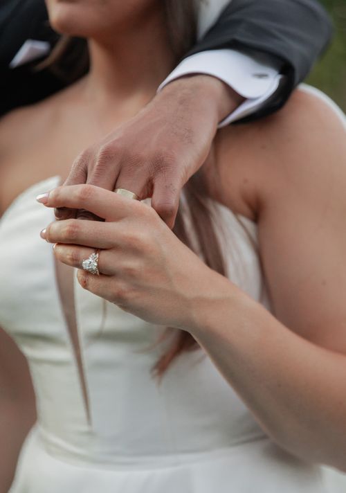 Free Romantic close-up of newlyweds' hands with wedding rings and elegant attire, symbolizing love. Stock Photo