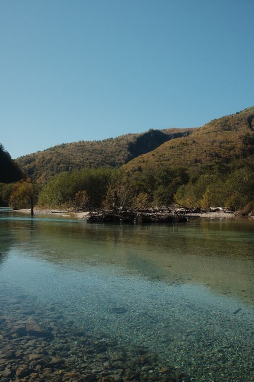 Free Tranquil river scene with clear water and lush hills in Matsumoto, Japan. Stock Photo