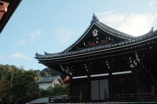 Free Beautiful view of a traditional temple roof in Kyoto, Japan, under a clear blue sky. Stock Photo