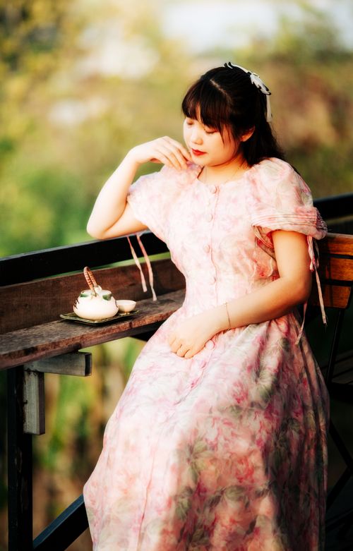 Free Peaceful scenic view of woman in pink floral dress sitting outdoors. Stock Photo