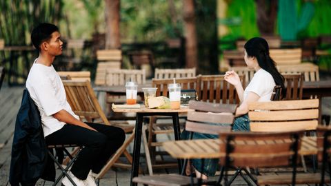 Two adults enjoying drinks at an outdoor cafe in Kon Tum, Vietnam.