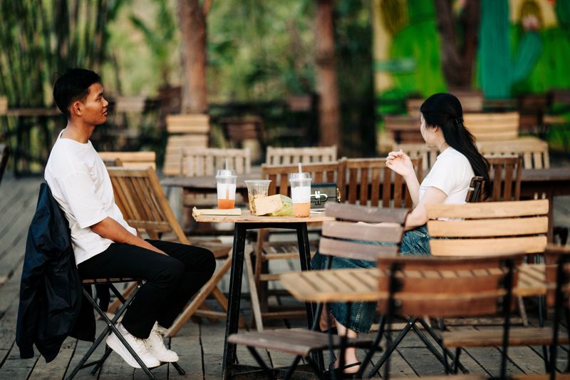 Two adults enjoying drinks at an outdoor cafe in Kon Tum, Vietnam.