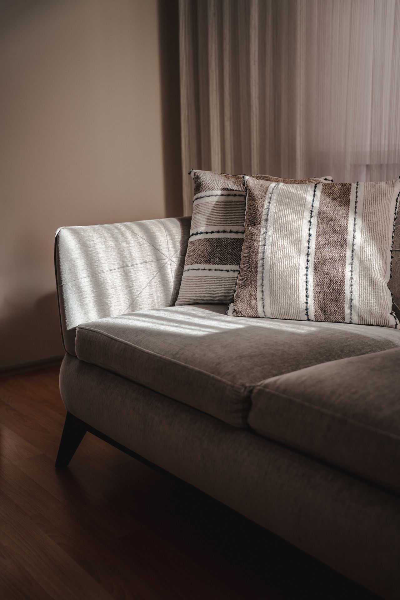 Light armchair with a pair of striped cushions in warm sunlight