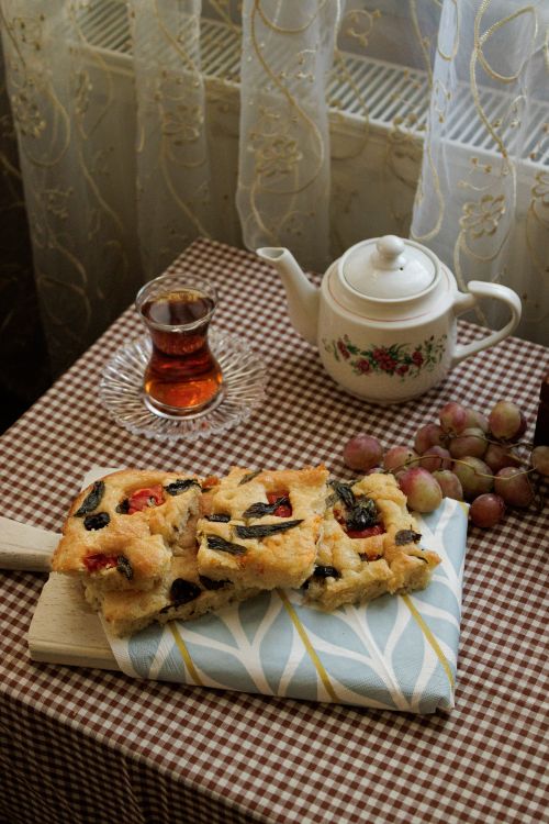 Free Cozy indoor tea setup with homemade pastries and ripe grapes on a checkered tablecloth. Stock Photo