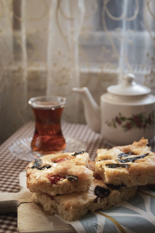 Free Cozy indoor tea setting with focaccia bread and a floral teapot, perfect for a warm, relaxing afternoon. Stock Photo