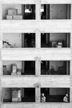 Black and white photo of industrial building under construction with workers, Buenos Aires.