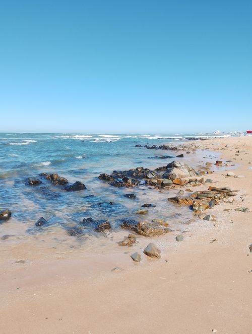 Free Serene beach landscape with rocky shoreline and clear blue skies in Casablanca, Morocco. Stock Photo