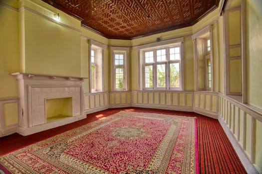 A spacious, elegant room with large windows, fireplace, and vibrant carpet in Jammu and Kashmir.