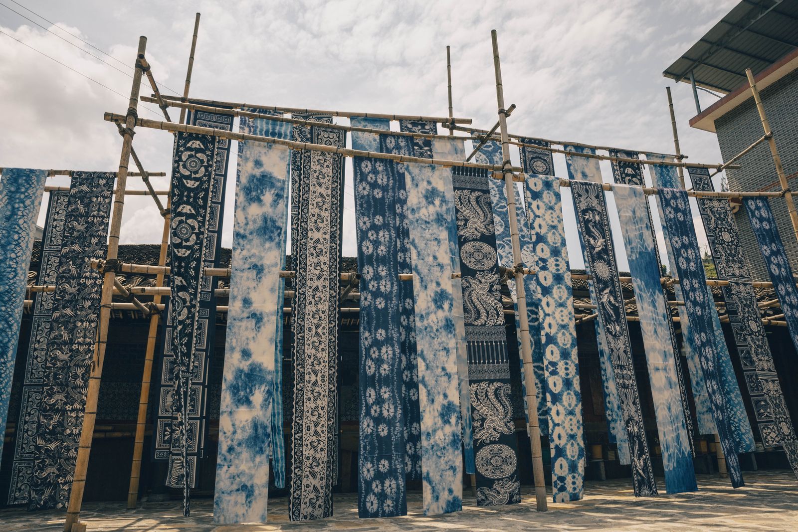 Indigo-dyed lengths of cloth hanging to dry in a courtyard