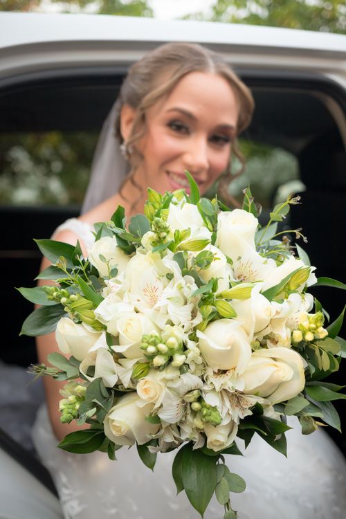 Free Bride holding an elegant white floral bouquet, showcasing wedding grace. Stock Photo