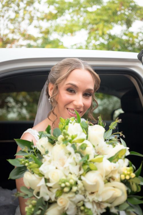 Free Radiant bride with elegant bouquet inside a car, ready for her wedding day. Stock Photo