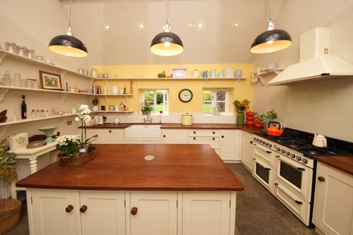 Free Charming farmhouse kitchen with elegant wood countertops, open shelving, and vintage decor. Stock Photo