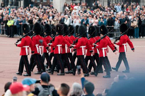 Free Changing of the Guard ceremony at Buckingham Palace, London, featuring soldiers in traditional red uniforms. Stock Photo