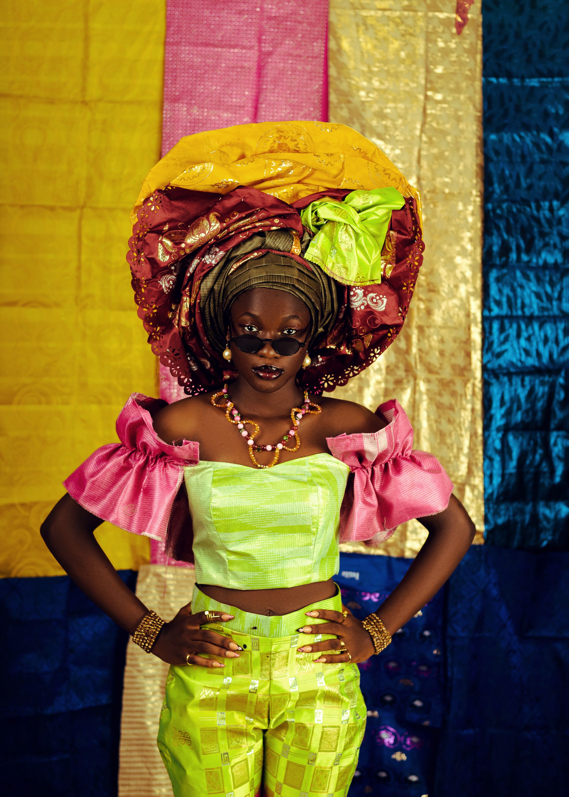 Vibrant portrait of a woman in traditional African attire, showcasing bold colors and intricate headwrap.