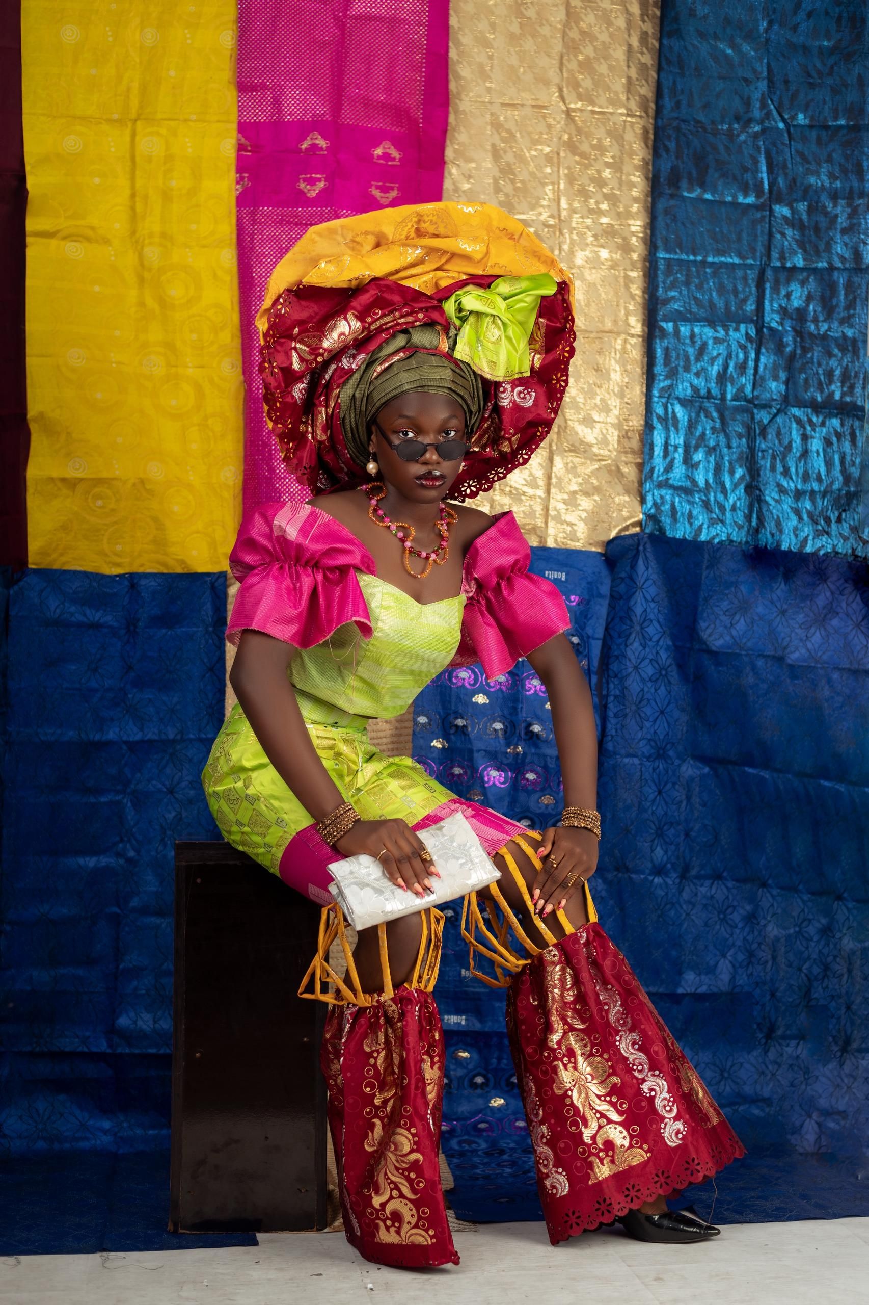 Elegant woman in colorful traditional African attire showcasing vibrant textiles.