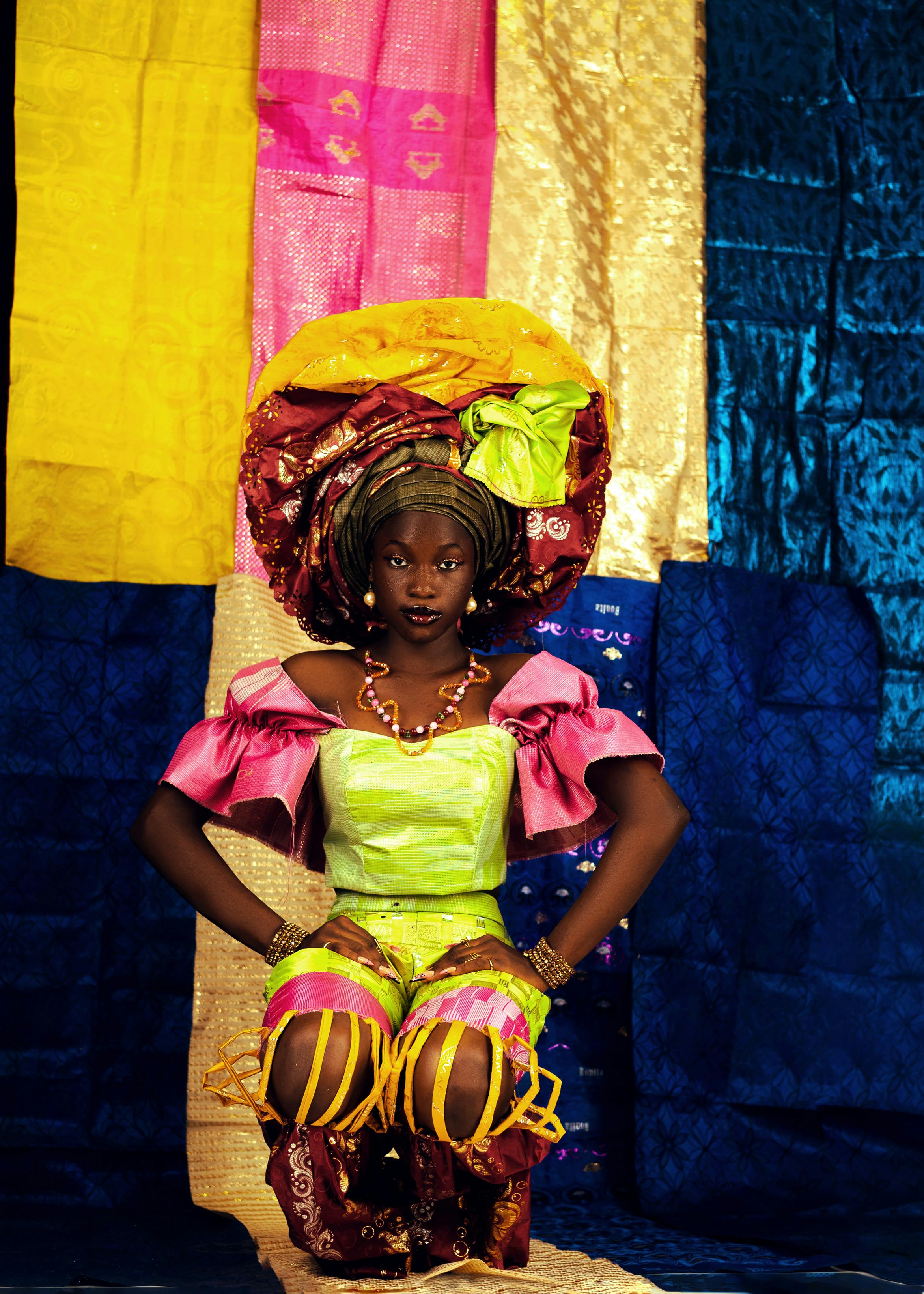 Woman in colorful traditional attire and headdress, embodying cultural richness.