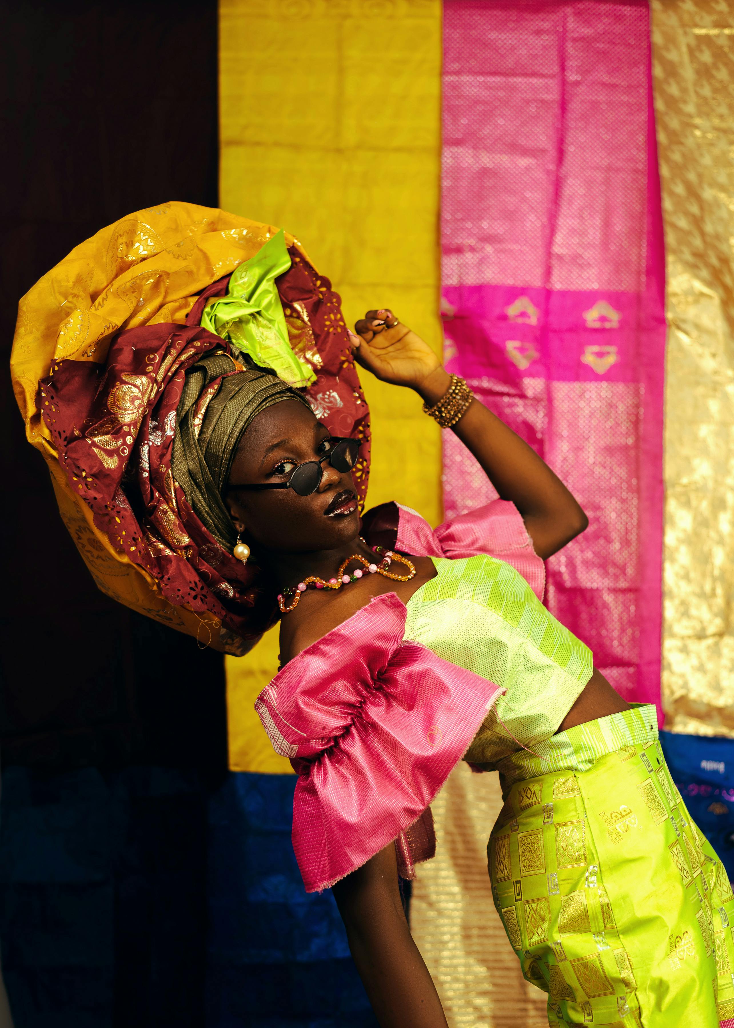 Vibrant portrait showcasing traditional African attire with colorful fabric background.