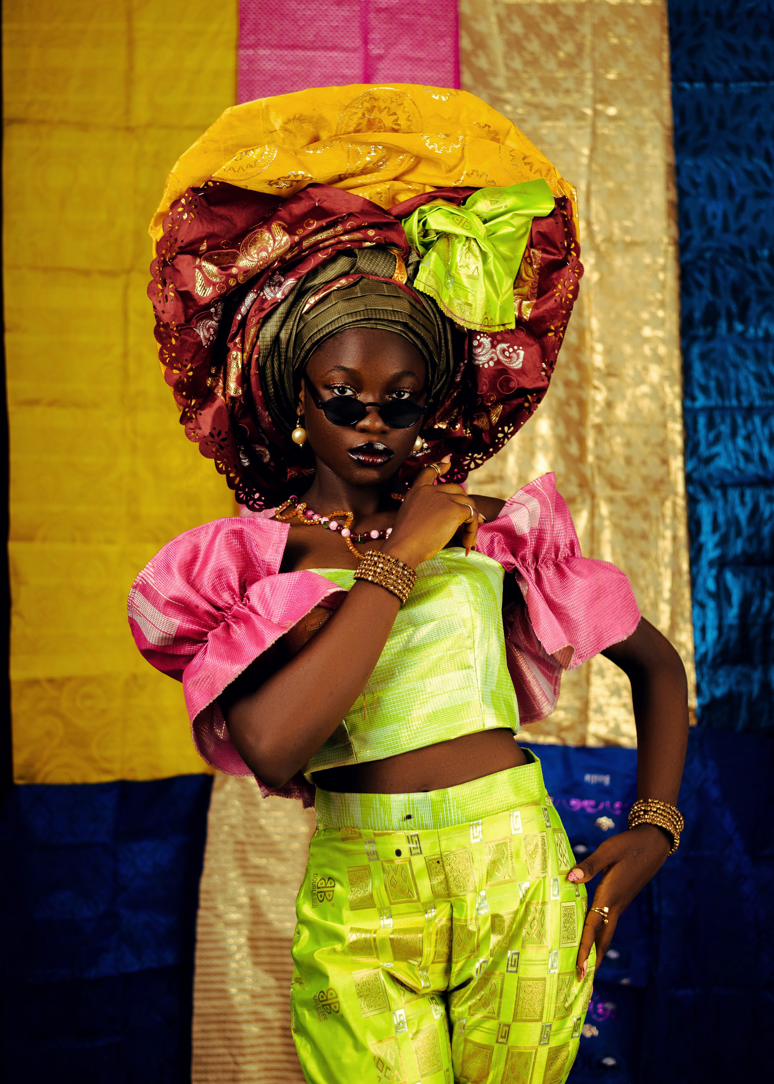Vibrant traditional African attire featuring a stunning headwrap and colorful patterns indoors.
