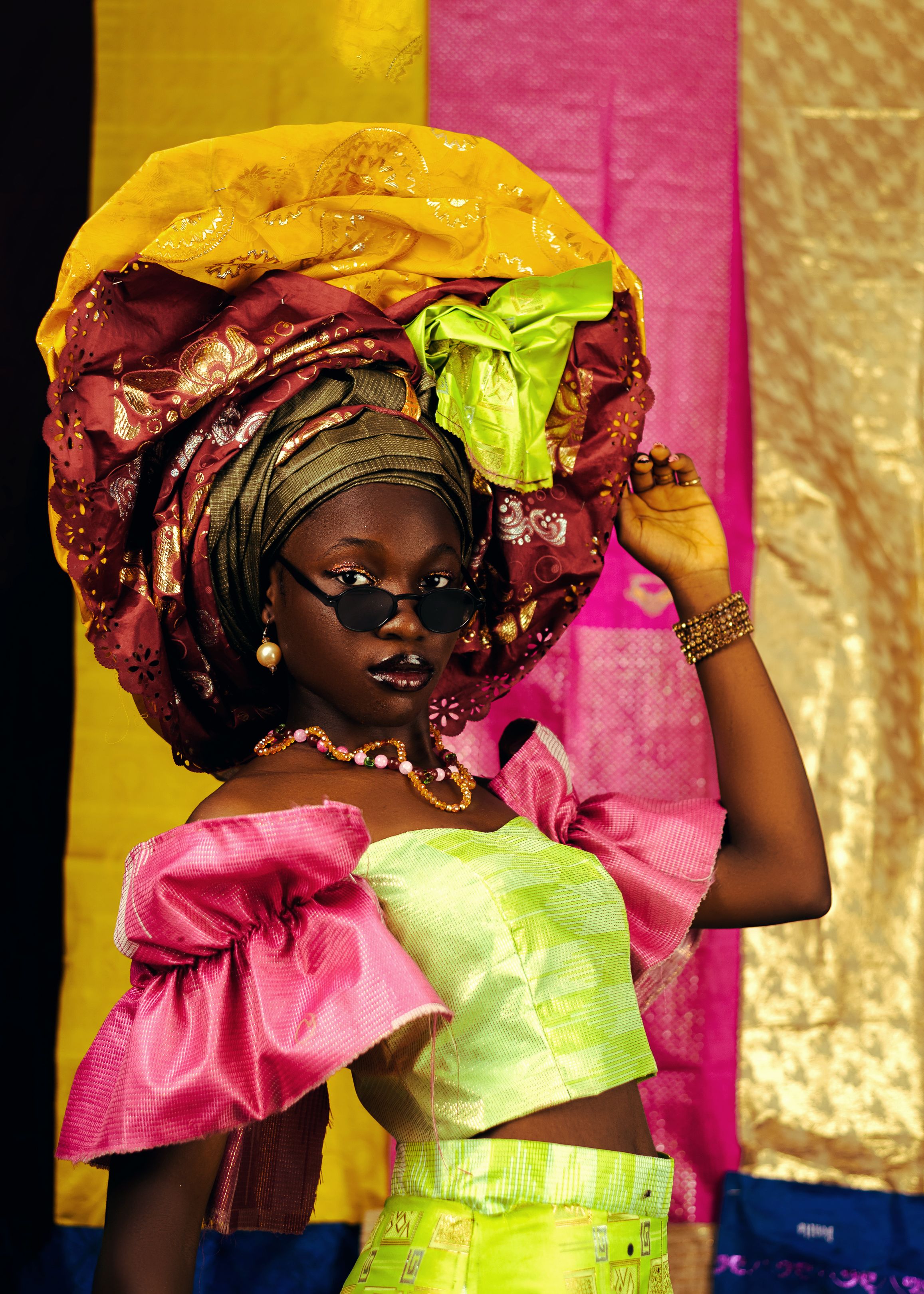 Stunning portrait of a woman in traditional African attire with colorful headwrap and jewelry.