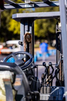 Detailed view of a forklift steering wheel with an outdoor bokeh background.