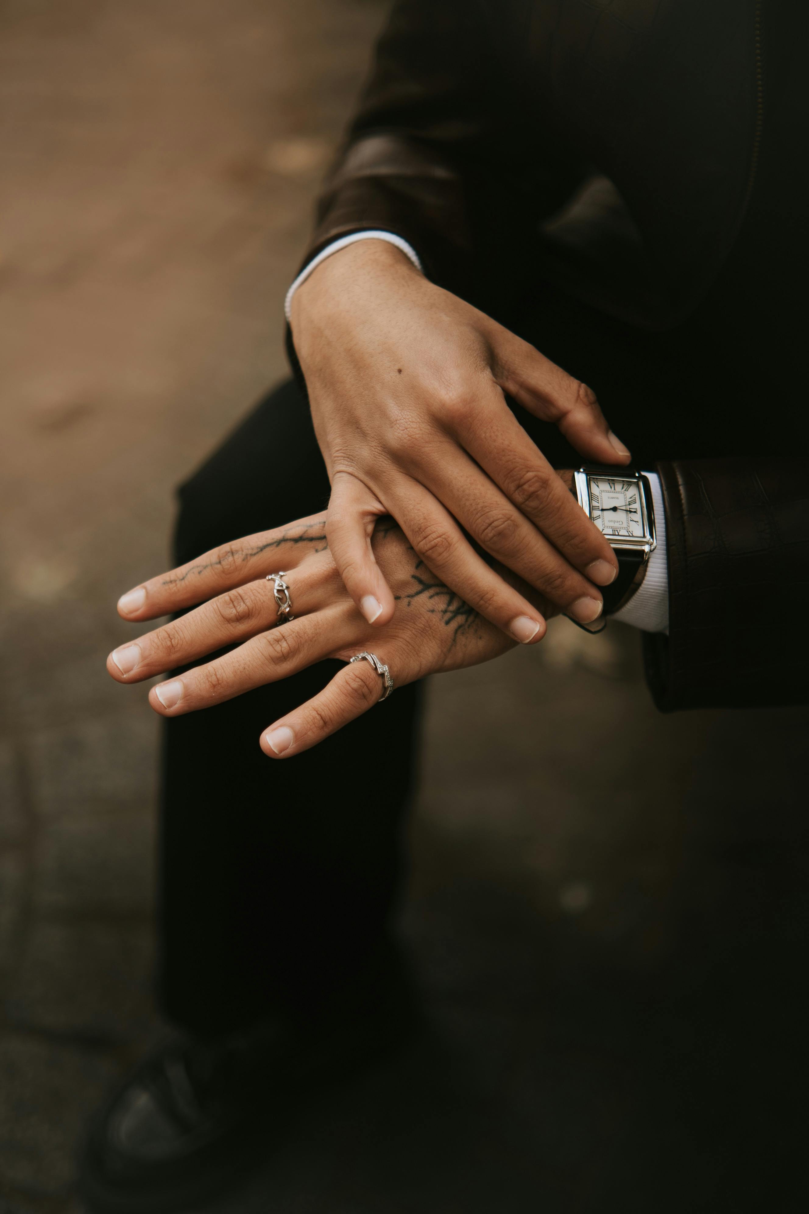 Close-up portrait of a fashionable man with tattoos and rings in Lille, France.