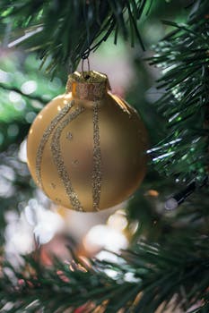 特写镜头捕捉到圣诞树上带有闪光图案的金色小玩意，展现了节日装饰的细节