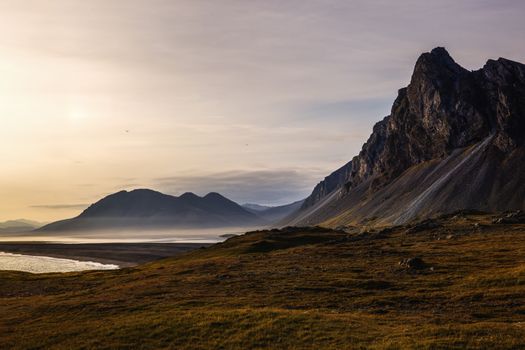 A breathtaking sunrise over rugged mountains and misty valleys, offering tranquility and natural beauty.