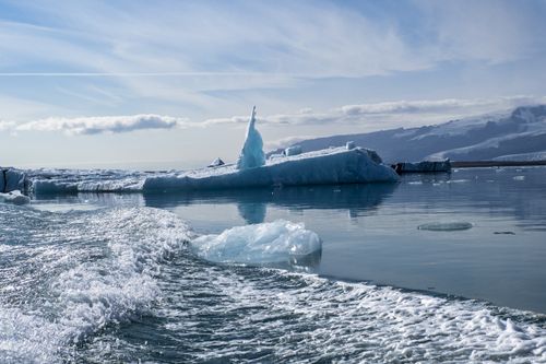 Free Serene view of icebergs floating in calm arctic waters under a clear blue sky. Stock Photo