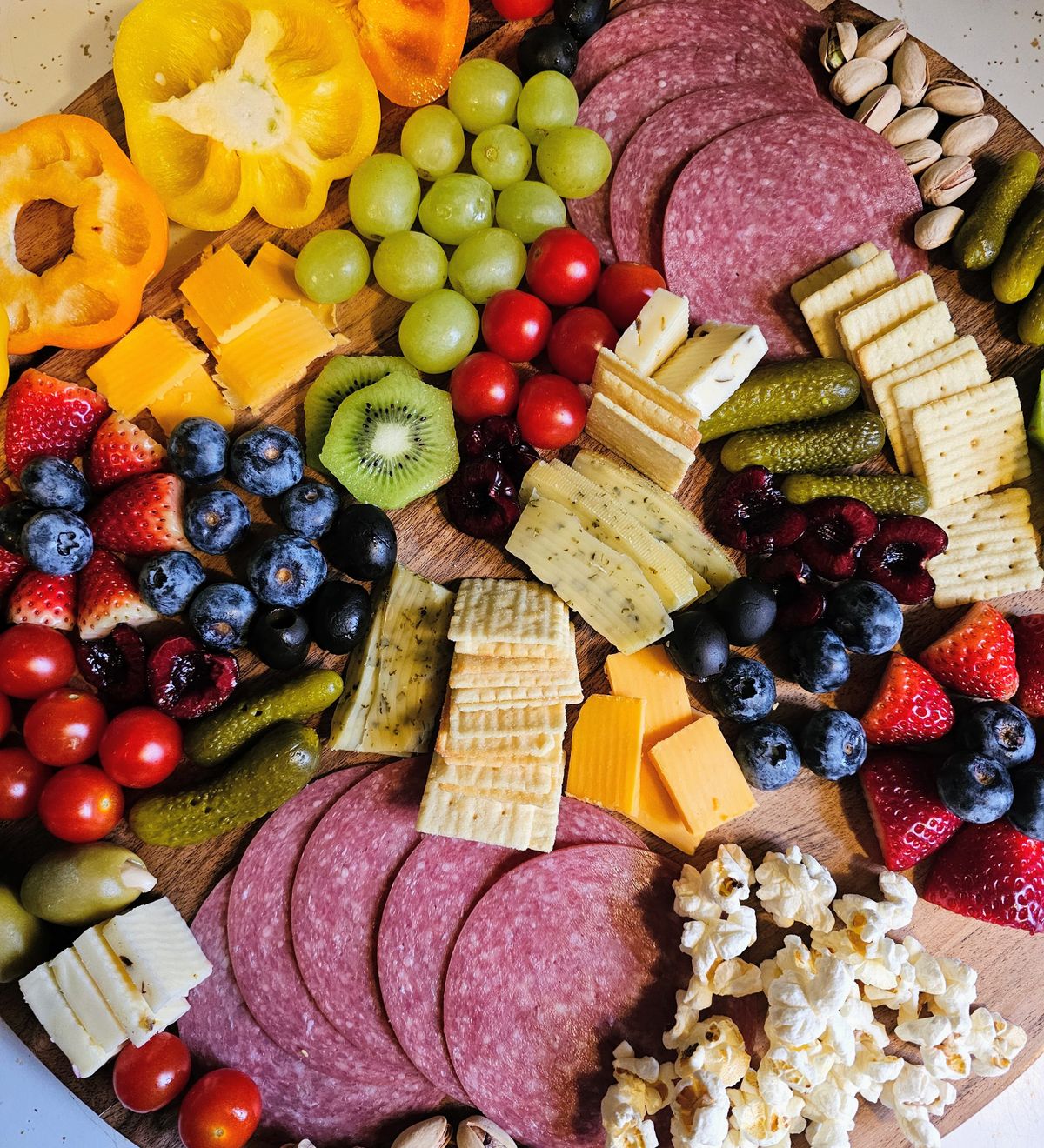 Thanksgiving kids table ideas with a colourful charcuterie board with cheese, fruit and snacks for a kids snack board