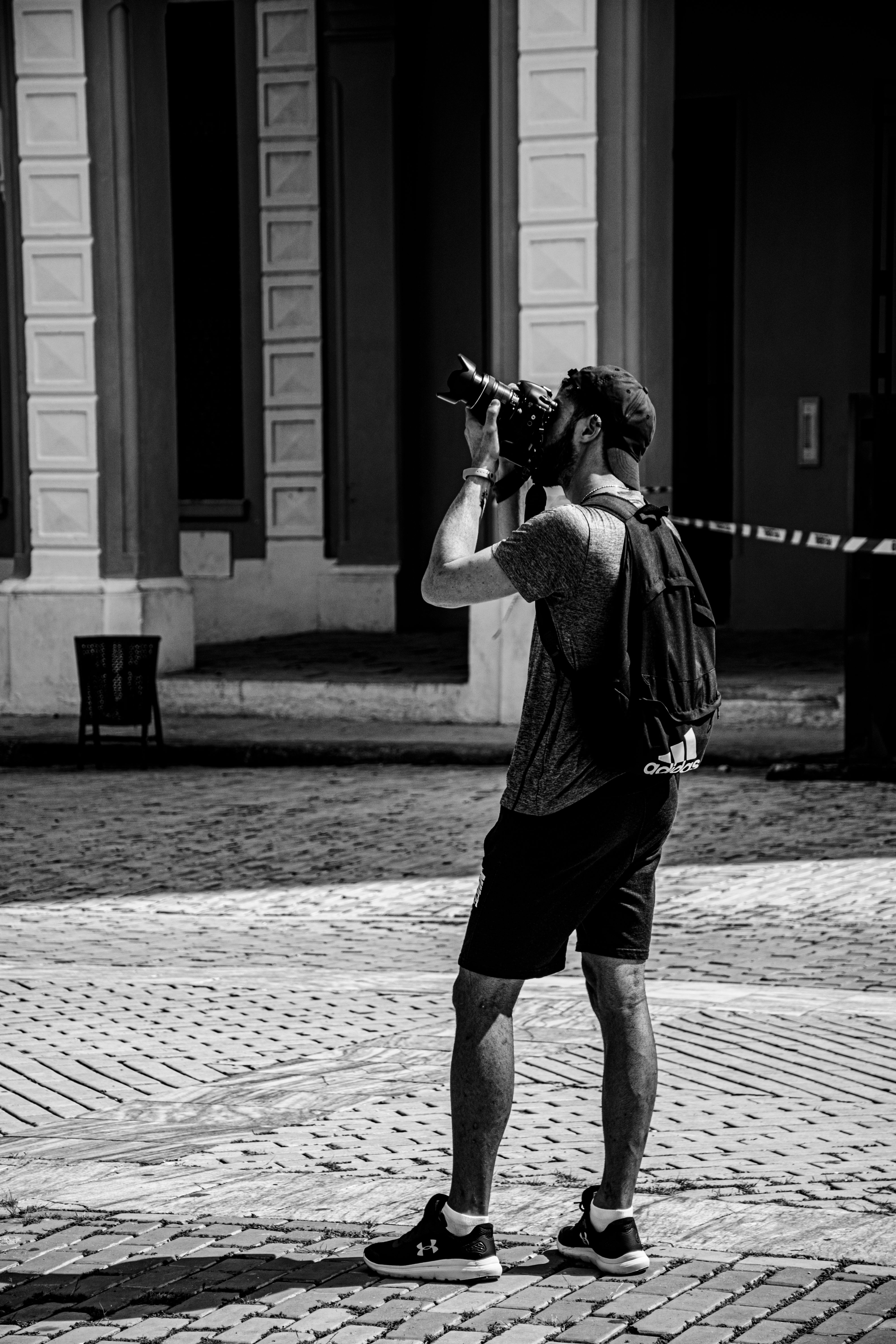 Monochrome image of a photographer capturing city architecture.
