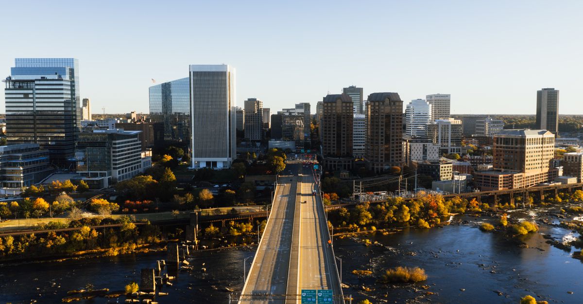 Aerial view of Richmond, Virginia skyline with bridge and river at dusk showcasing city architecture.