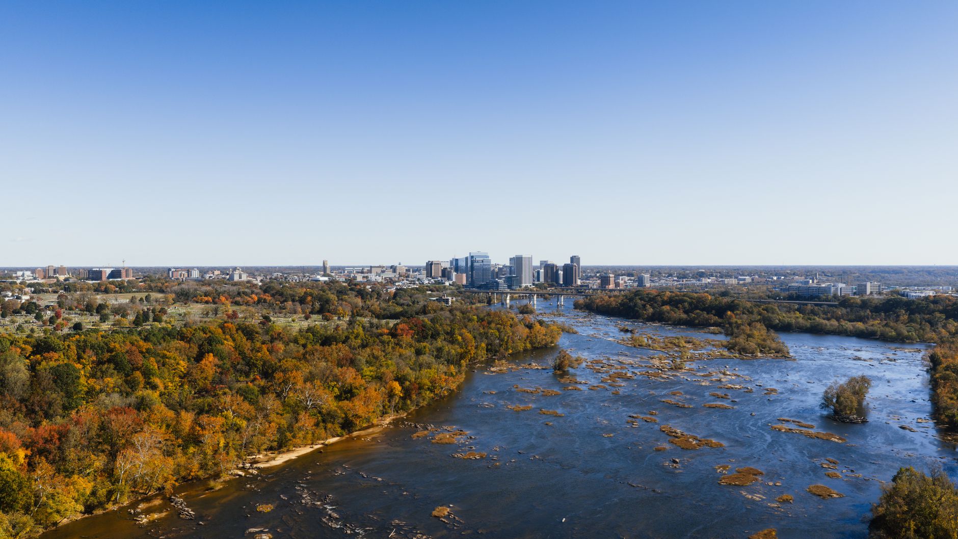 A stunning aerial view of the Richmond city skyline with fall foliage along the James River.