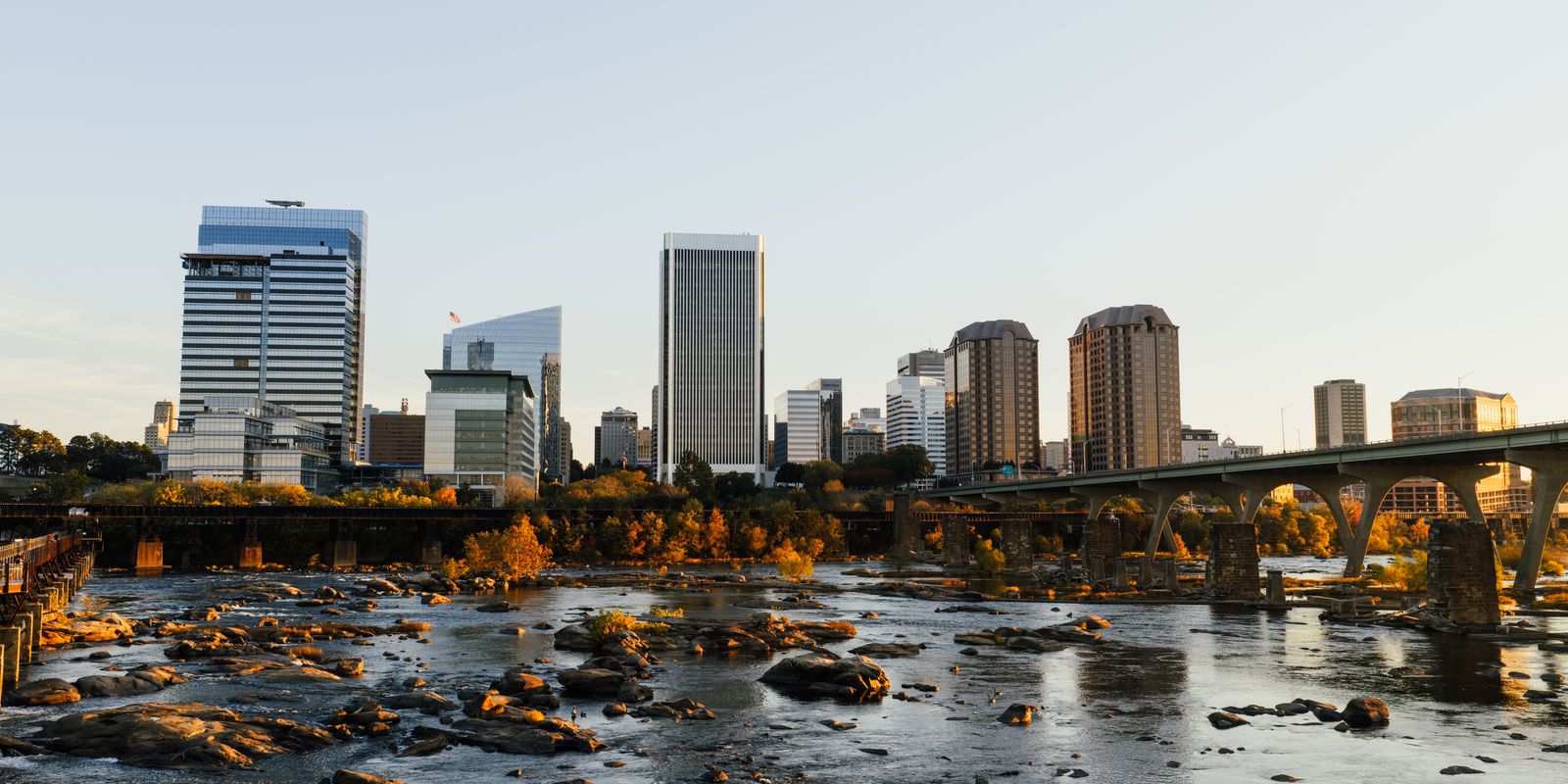 A city skyline along a river at sunset