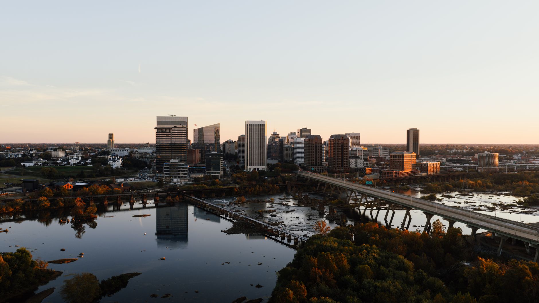 Stunning aerial shot of Richmond, Virginia skyline with river reflection at sunset.