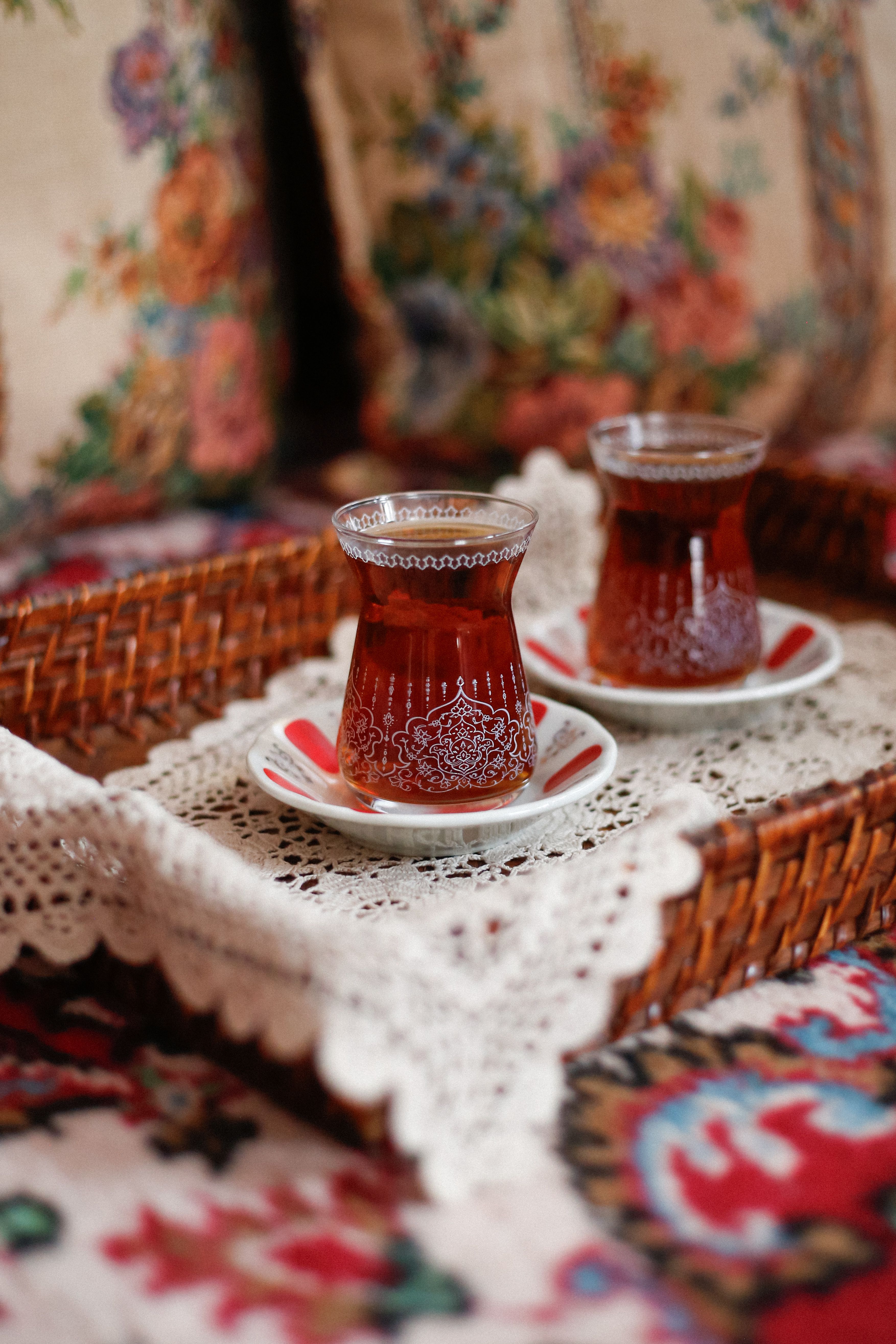 Elegant Turkish tea served in traditional glasses on a decorative wicker tray.