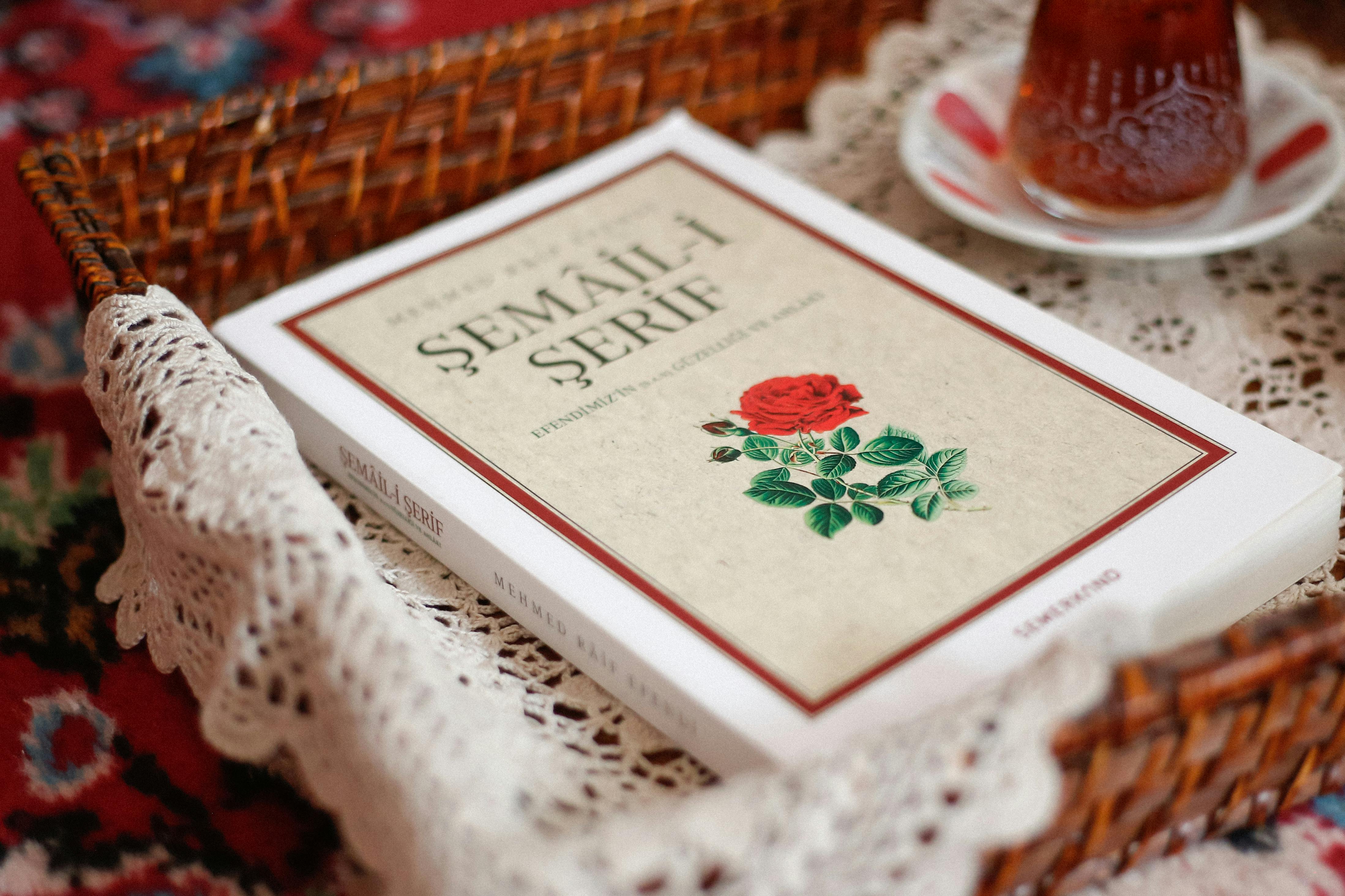 An artistic setup with a Turkish book in a wicker basket and a cup of tea on a lace doily.