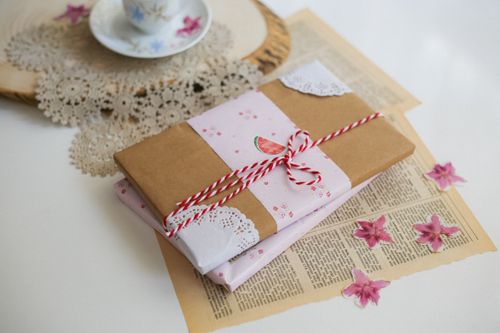 Free Chic gift wrapped in brown and pink with delicate floral accents, perfect for special occasions. Stock Photo