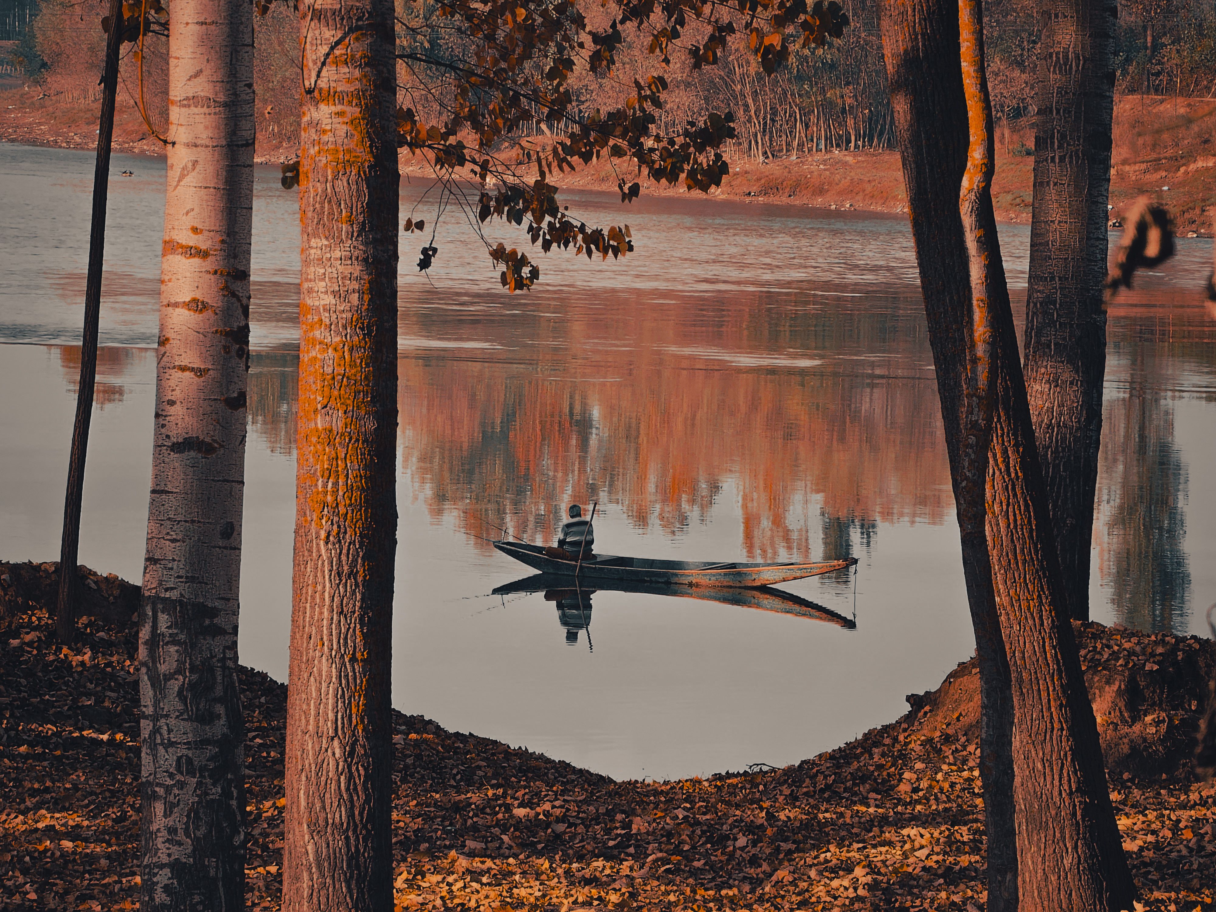 Serene Autumn Lake with Small Fishing Boat · Free Stock Photo
