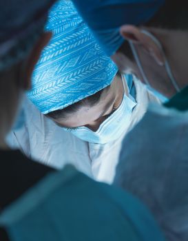 Surgeons intensely operating in a well-equipped operating room.