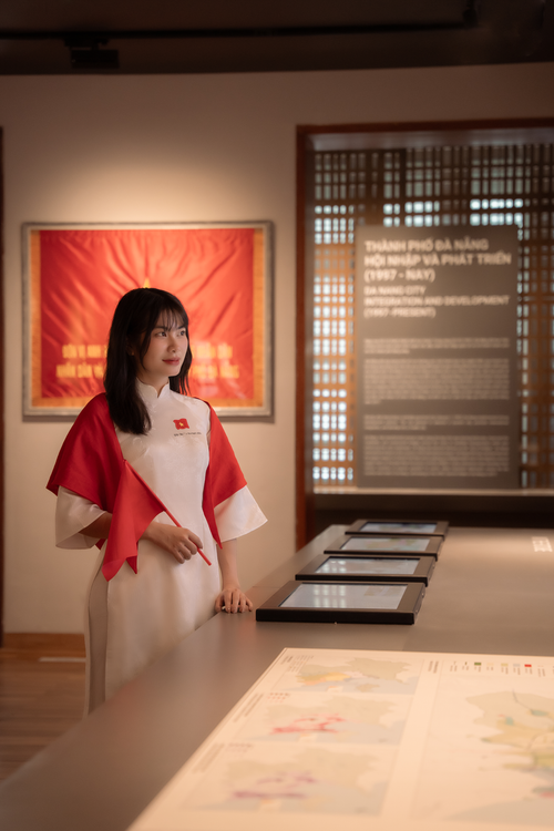 Free Young woman in traditional dress explores history exhibit indoors. Stock Photo