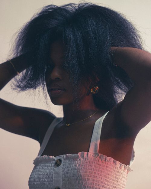 Free Artistic portrait of a woman with natural afro hair wearing stylish jewelry. Stock Photo