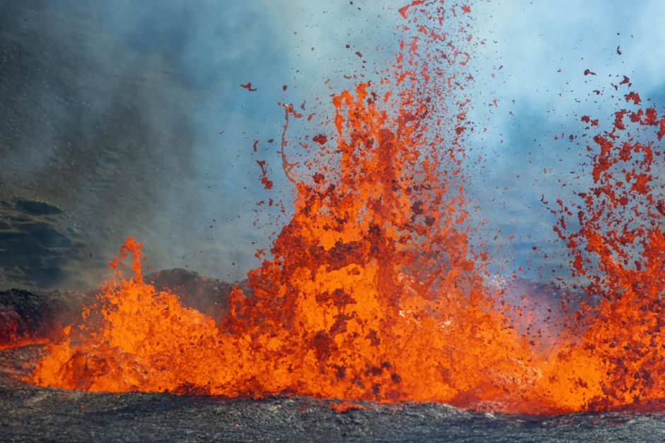 Close-up of vibrant orange lava erupting from a volcano, capturing the intensity and power of nature.