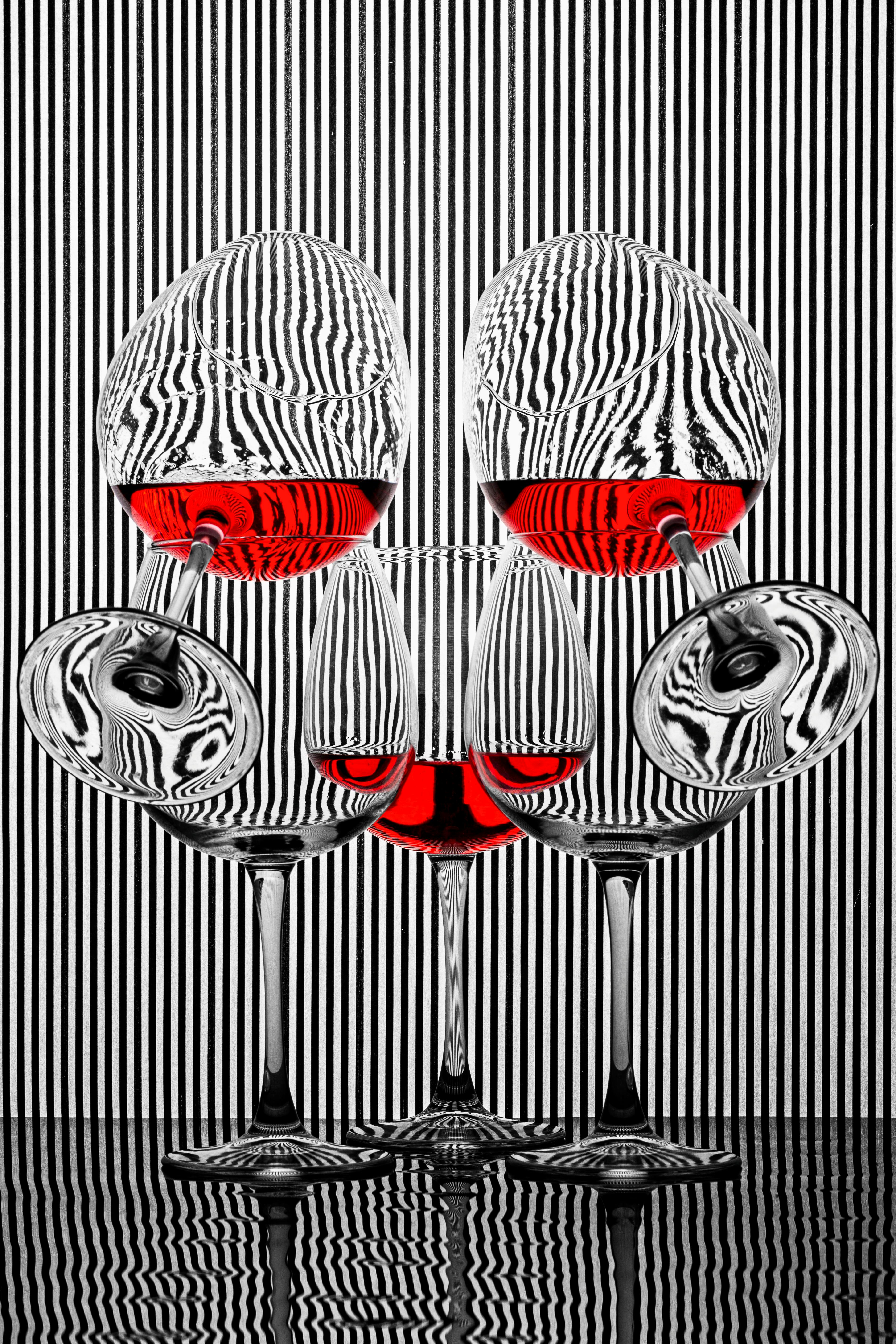 Gratis Foto artistik gelas anggur dengan cairan merah dan pola ilusi optik. Foto Stok