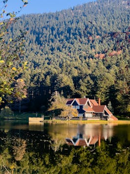 Serene lake house surrounded by lush forest and mountain reflections in Bolu, Türkiye.