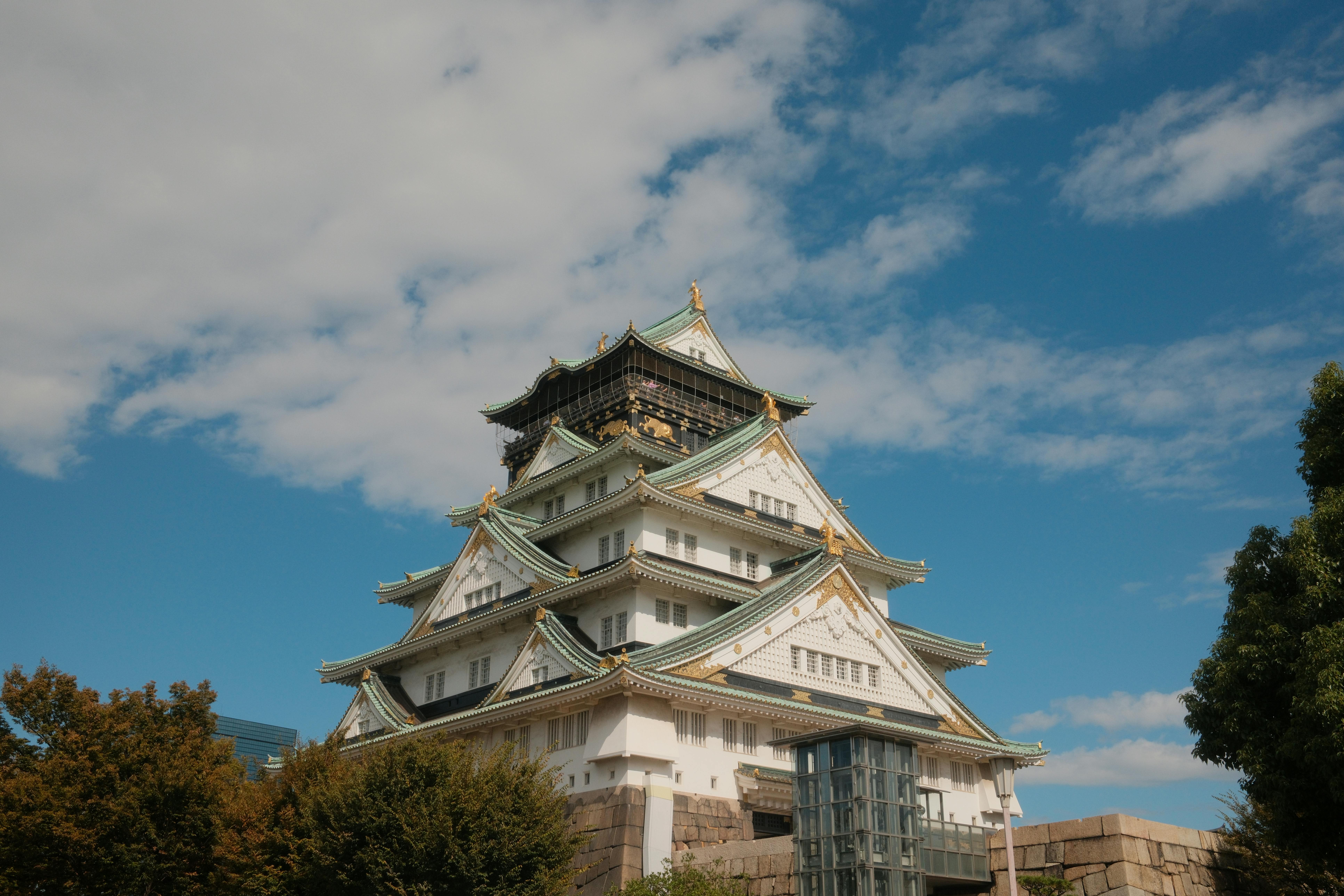 Nagoya Castle's soaring white tower keep with two golden shachihoko gleaming against a crisp blue autumn sky