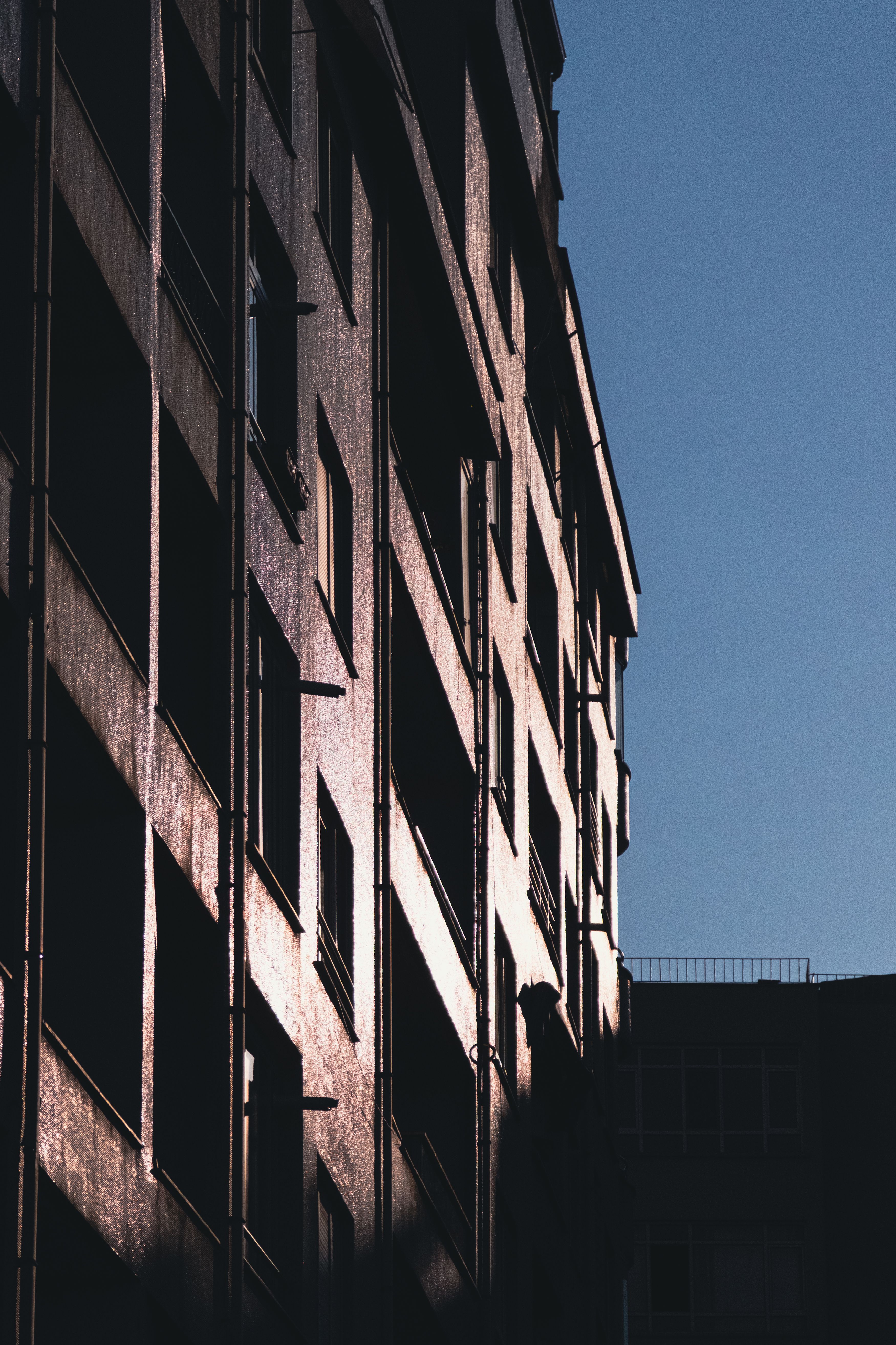 Urban building facade with shadow play · Free Stock Photo