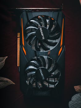 Detailed close-up of a black and orange graphic card with cooling fans.