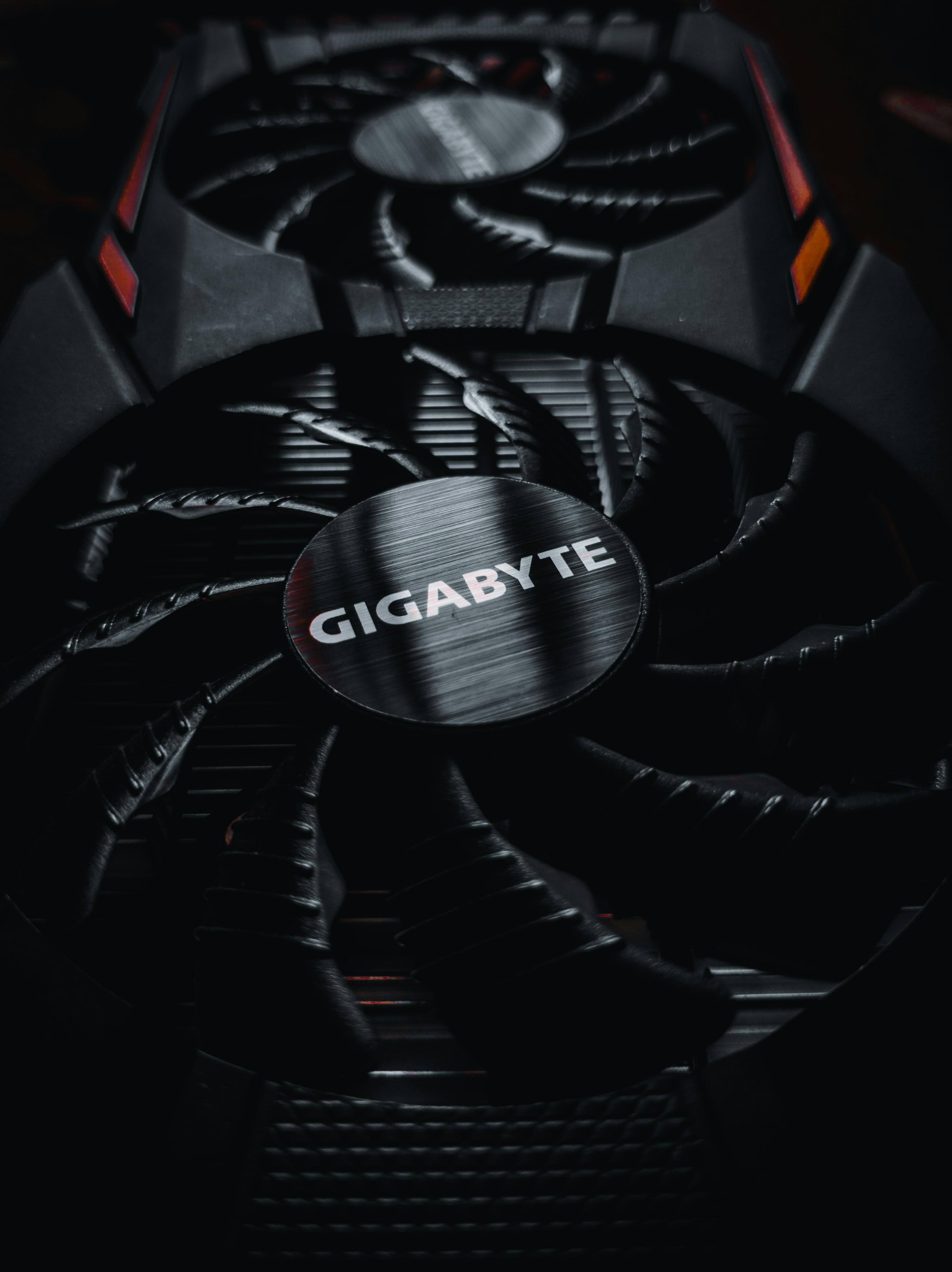 Free Detailed view of a Gigabyte graphics card fan with sleek design elements. Stock Photo
